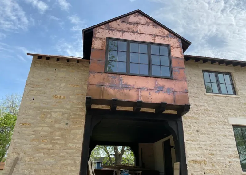 Copper metal panel facade on a stone building for Roof Repair in Camas